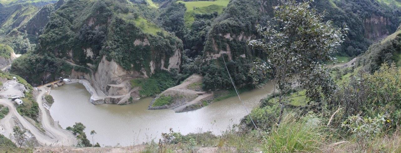 Embalse de la captación en el fondo del cañón, entre laderas con vegetación
